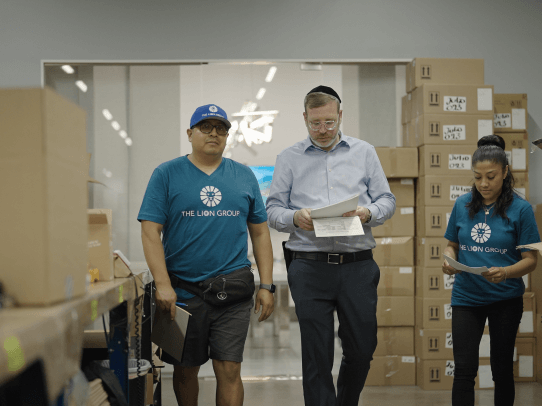 CEO walking with employees in a warehouse